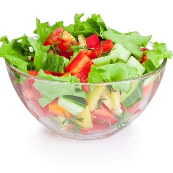Fresh garden salad with lettuce, tomatoes, cucumbers, and bell peppers in a glass bowl.