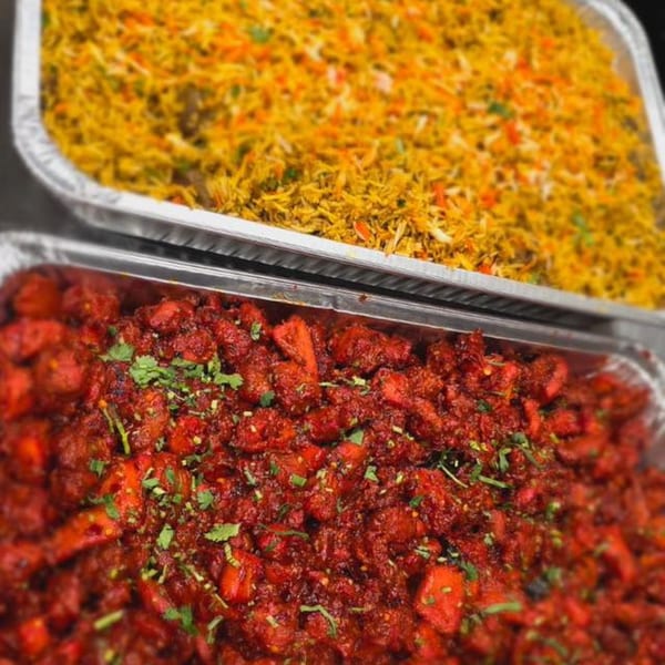 Two foil trays of Indian food: yellow biryani rice and red chicken tikka masala with cilantro.